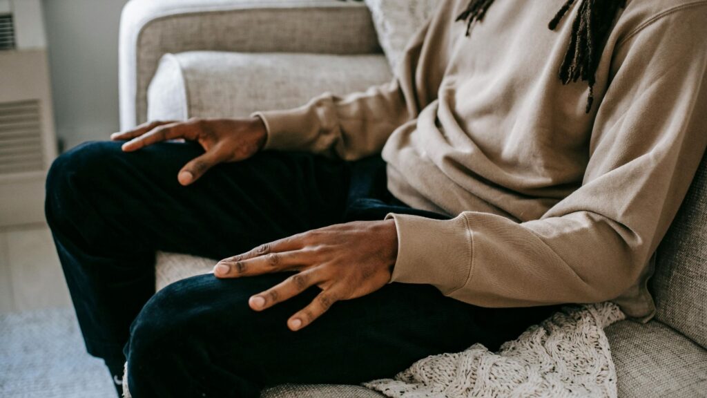 Image of an African American man in therapy for PTSD with hands on his lap.