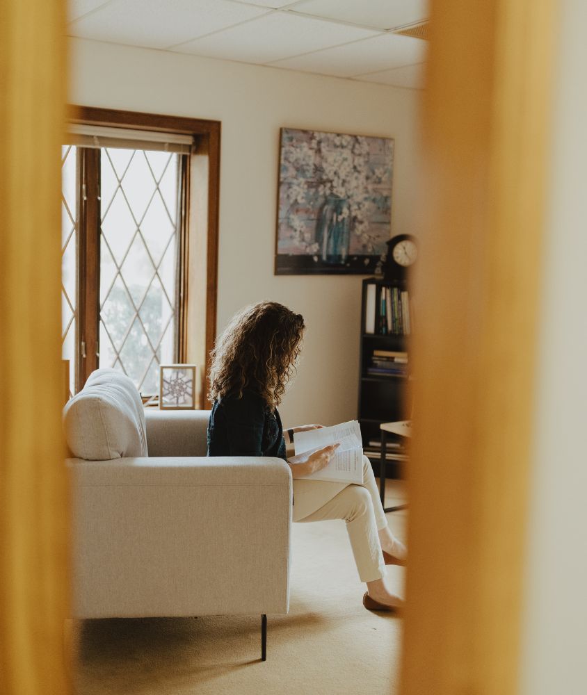 Trauma therapist Melissa sitting in a white chair in her office in solon OH